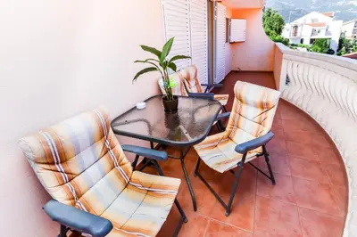 a table and chairs on a balcony with a plant at Apartment Mario in Budva