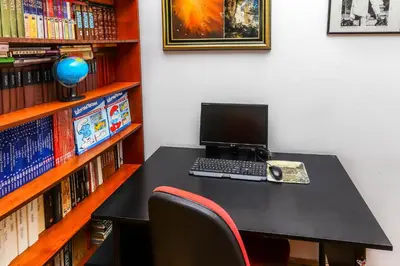 a desk with a laptop computer on it next to a book shelf at Apartment Mario in Budva