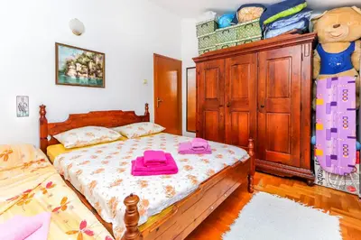 a bedroom with two beds and a wooden cabinet at Apartment Mario in Budva