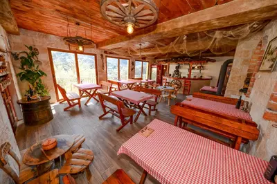 a restaurant with tables and chairs in a room at Skadar lake Apartments Pajovic in Virpazar