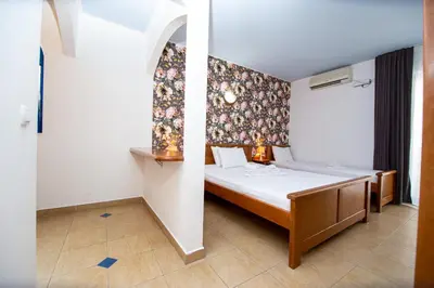 a bedroom with a bed with a floral wall at Tanja Apartments in Rafailovici