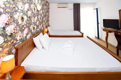 a bedroom with a bed with a floral wall at Tanja Apartments in Rafailovici