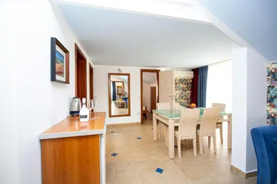 a living room and dining room with a table and chairs at Tanja Apartments in Rafailovici