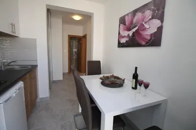 a kitchen with a white table with two glasses of wine at Luxury Apartment Stefan in Sveti Stefan