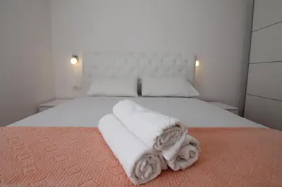 a bedroom with a white bed with towels on it at Luxury Apartment Stefan in Sveti Stefan