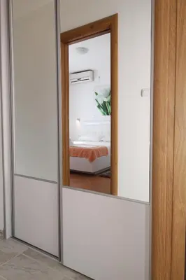 a mirror in front of a bedroom with a bed at Luxury Apartment Stefan in Sveti Stefan