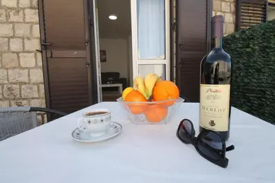 a bottle of wine and a bowl of fruit and a cup of coffee at Luxury Apartment Stefan in Sveti Stefan