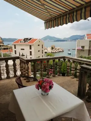a table with a vase of flowers on a balcony at Luxury Apartment Stefan in Sveti Stefan