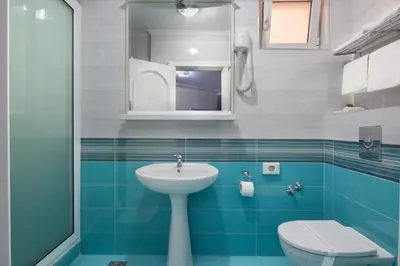 a blue and white bathroom with a sink and a toilet at Hotel Bella Vista in Budva