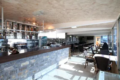 a restaurant with a bar with tables and chairs at Hotel Bella Vista in Budva
