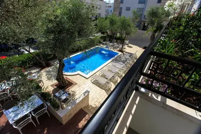 an overhead view of a swimming pool with chairs and a balcony at Hotel Harmony by Aycon in Petrovac na Moru