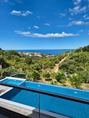 a villa with a swimming pool and a view of the ocean at Apartments Merin in Utjeha