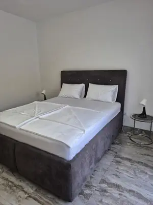 a large bed with white sheets and pillows on it at Apartments Merin in Utjeha