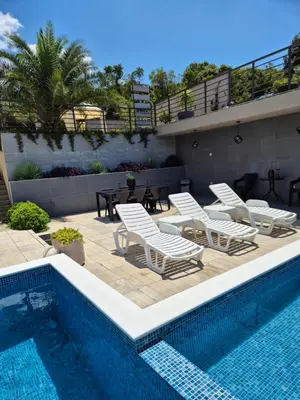 a pool with chaise lounge chairs and a swimming pool at Apartments Merin in Utjeha