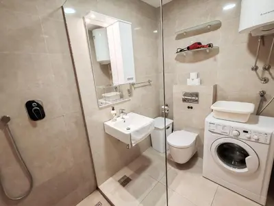 a bathroom with a toilet and a sink and a washing machine at Andrey Apartment in Budva
