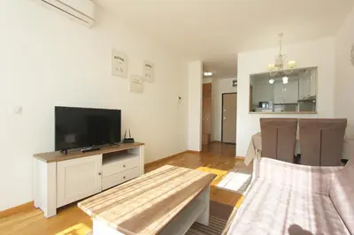 a living room with a flat screen tv and a table at Andrey Apartment in Budva