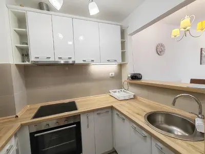 a kitchen with white cabinets and a sink at Andrey Apartment in Budva
