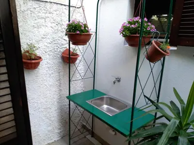 a bathroom with a sink and potted plants at Guest house Villa Castio in Petrovac na Moru