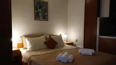 a bedroom with a bed with two slippers on it at Guest house Villa Castio in Petrovac na Moru