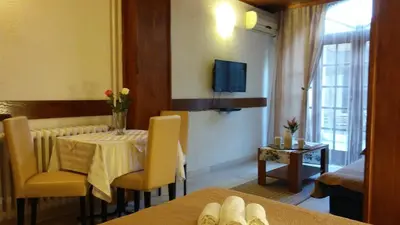 a living room with a table and chairs and a television at Guest house Villa Castio in Petrovac na Moru