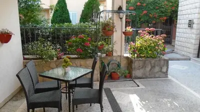 a patio with a table and chairs and potted plants at Guest house Villa Castio in Petrovac na Moru