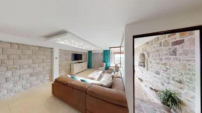 a living room with a couch and a brick wall at Luka Villa in Becici