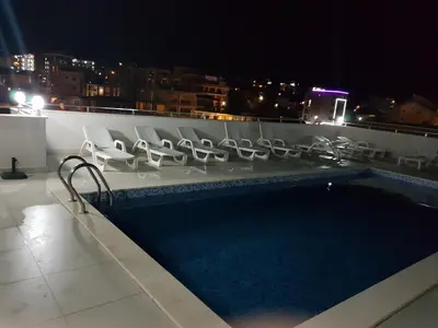 a swimming pool on the roof of a building at night at Apartment Melina in Dobra Voda