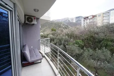 a balcony with a chair and a view of a mountain at Anja Apartment in Rafailovici