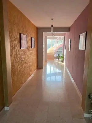 a hallway with pink walls and a tile floor at Anja Apartment in Rafailovici