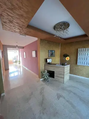 a large living room with a fireplace and pink walls at Anja Apartment in Rafailovici