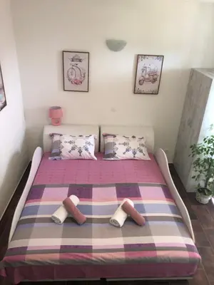 a bedroom with a bed with two slippers on it at Vila POGLED in Bar