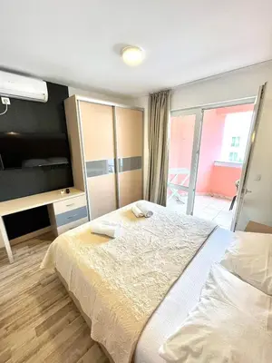a bedroom with a large bed and a television at Apartments Sofija in Budva
