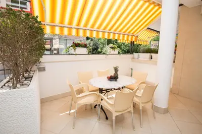 a table and chairs on a patio with a yellow ceiling at Apartments Sofija in Budva