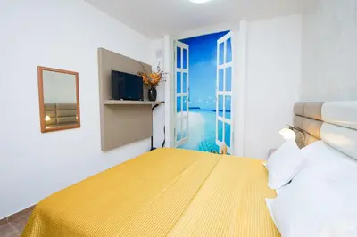 a bedroom with a yellow bed and a window at Apartments Sofija in Budva