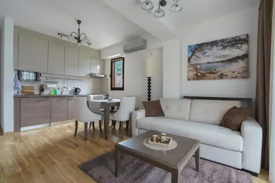 a living room with a couch and a table and a kitchen at Apartments LORA Jadranskij put in Budva