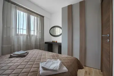 a bedroom with a bed with a mirror and a window at Apartments LORA Jadranskij put in Budva