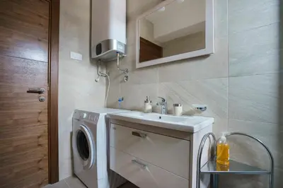 a bathroom with a washing machine and a sink at Apartments LORA Jadranskij put in Budva