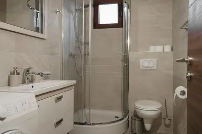 a bathroom with a shower and a toilet and a sink at Apartments LORA Jadranskij put in Budva