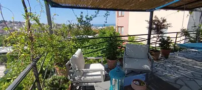 a balcony with two chairs and potted plants at Holiday Home Free your mind in Dobra Voda