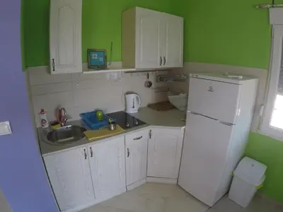 a kitchen with white cabinets and a white refrigerator at Holiday Home Free your mind in Dobra Voda