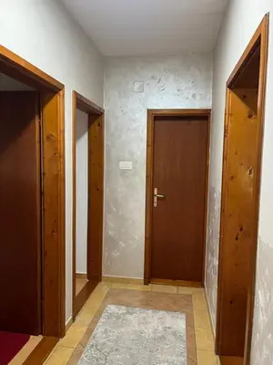 an empty hallway with two doors and a rug at Apartment Helena Airport in Podgorica