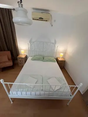 a bedroom with a white bed and two lamps at Apartment Dijana in Petrovac na Moru