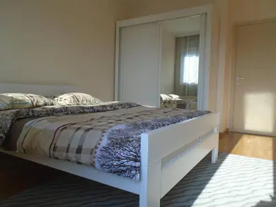 a bedroom with a bed with a large mirror at Fantastic brand new apartment in Podgorica