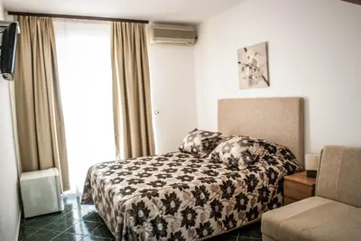 a hotel room with a bed and a window at Apartments & Rooms Elite in Dobra Voda