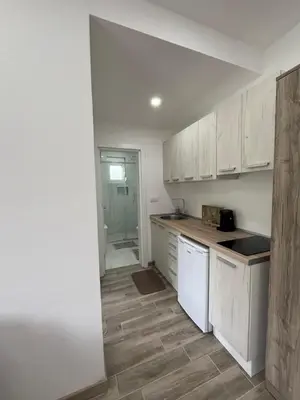 an empty kitchen with white cabinets and a floor at Demiri Rr in Ulcinj