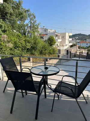 a glass table and two chairs on a patio at Demiri Rr in Ulcinj