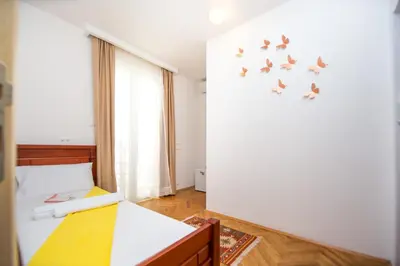a bedroom with a bed with birds on the wall at Villa DiEden in Budva