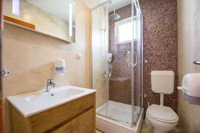 a bathroom with a sink and a toilet and a shower at Villa DiEden in Budva