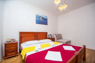 a bedroom with a large bed with a red and yellow blanket at Villa DiEden in Budva