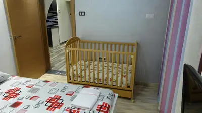 a crib in a room next to a bedroom at Apartment Kraljica Jelena in Virpazar